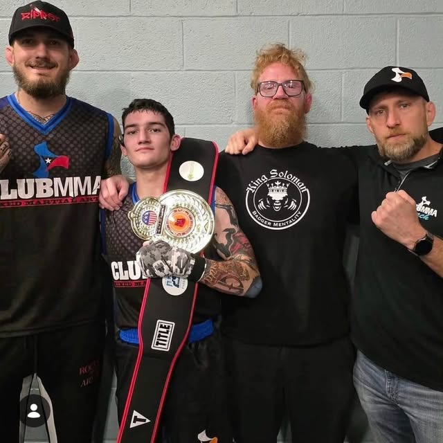 Solomon, second from left, with his championship belt and teammates